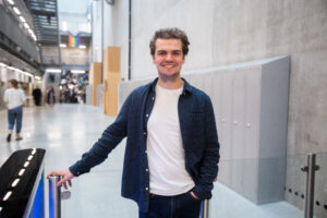 Image shows Carleton Hobbs Bursary Award winner Josh Bryant-Jones stood smiling in the Mountview atrium.